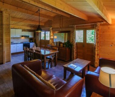 Intérieur de chalet avec salon canapés et cuisine du Domaine de Maples