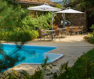Bord de piscine avec terrasse parasols et chaises au Domaine de Maples