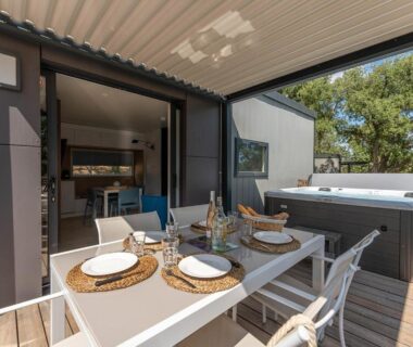 Terrasse avec table à manger et jacuzzi au Domaine de Miremer