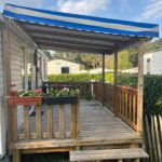 Terrasse en bois couverte avec auvent rayé et jardinières au Domaine de kerlann 281