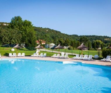Piscine extérieure avec transats et parasols au Domaine de l'Epinette