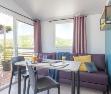 Séjour avec canapé table et terrasse ouverte au Domaine de l'Epinette