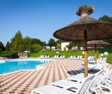Piscine extérieure avec transats et parasols au Domaine de l'Epinette