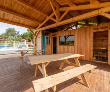 Terrasse en bois avec bancs et piscine au Domaine de la Cambre