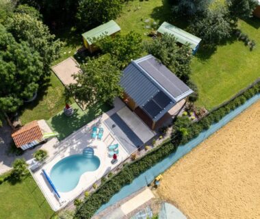 Piscine extérieure entourée de transats et de pelouse vue du ciel au Domaine de la Cambre