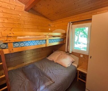 Intérieur du chalet en bois avec lit superposé au Domaine de la Chêneraie