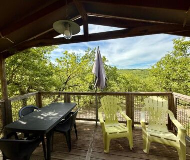 Terrasse en bois avec chaises et table vue sur la forêt au Domaine de la Faurie