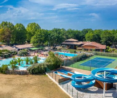 Piscine extérieure avec toboggans et terrain de tennis au Domaine de la Forge