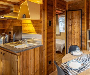 Intérieur du mobil-home avec coin cuisine et chambre au Domaine de la Forge