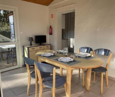 Salle à manger avec table dressée et télévision dans le Domaine de la Presqu'île