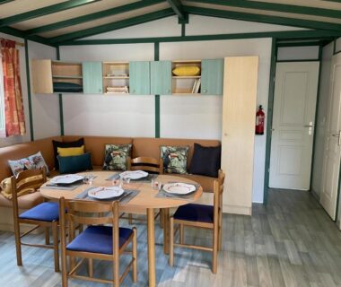 Séjour avec coin repas et table dressée dans le mobil-home du Domaine de la Presqu'île