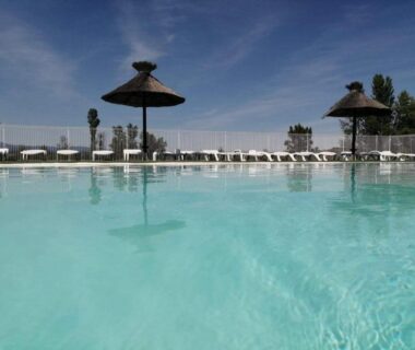 Piscine extérieure avec parasols et transats au Domaine des Garrigues