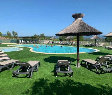 Piscine extérieure avec transats et parasols sur pelouse au Domaine des Garrigues