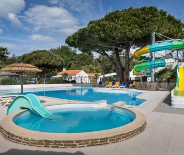 Espace piscine extérieure avec toboggans bassin ludique et transats au Domaine des Salins