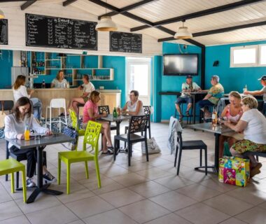 Salle conviviale avec tables et bar au Domaine des Salins