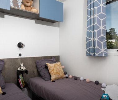 Chambre avec deux lits coussins et fenêtre au Domaine des Salins