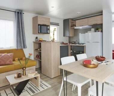 Séjour avec canapé coin repas et kitchenette dans le mobil-home du Domaine du Blanc Pignon