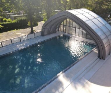 Piscine extérieure avec abri rétractable au camping Domaine du Lac Chambon