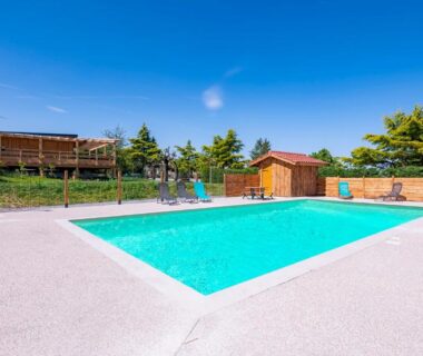 Piscine extérieure avec bord en béton et cabane dans le Dôme insolite du parc régional du Pilat