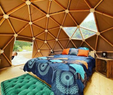 Intérieur de dôme avec lit et fenêtres sur la nature dans le Dôme insolite du parc régional du Pilat