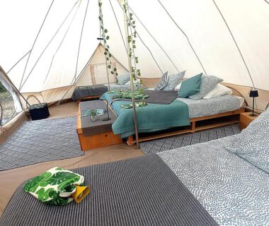 Intérieur de tente avec lits et coussins dans le Dordogne Glamping et Camping