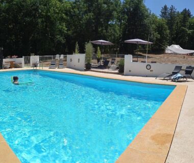 Piscine extérieure avec parasols transats et nageur au Dordogne Glamping & Camping