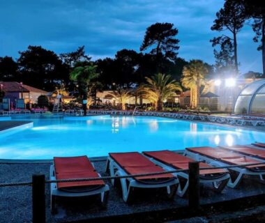 Piscine extérieure éclairée la nuit au camping Douce Escale