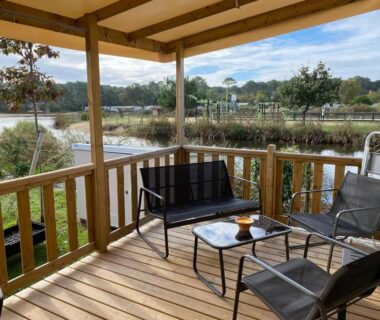 Terrasse couverte avec mobilier extérieur donnant sur l'étang au camping Douce Escale