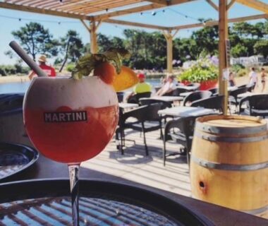Terrasse ombragée avec verre de cocktail et piscine au Douce Escale