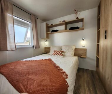 Chambre avec lit double et plaid orange dans le Dreamy Lodge Plaisir et Plage à 100m