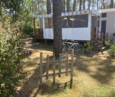 Terrasse couverte avec deux vélos et pins au camping Dunes 209