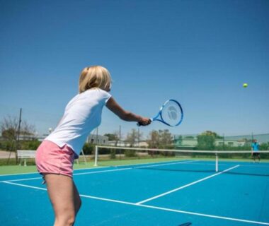 Terrain de tennis extérieur avec joueuse au camping EA - Votre séjour 4 étoiles 3 ch 2 SDB