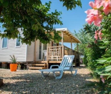 Terrasse ombragée avec fauteuils et jardin au mobil home EA Votre séjour 4 étoiles 3 ch 2 SDB