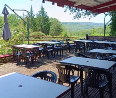 Terrasse couverte avec tables et chaises donnant sur la vallée de Dordogne de l'EMPLACEMENT TENTE En FORET
