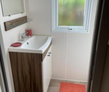 Salle de bain compacte avec lavabo et fenêtre dans le mobile home ESCALE BASSIN au Village LES VIVIERS