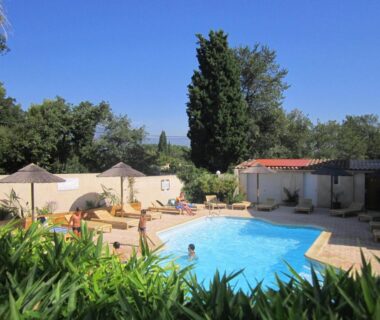 Piscine entourée de transats et parasols dans le jardin de l'Eco-Lodge Lou Pantaï