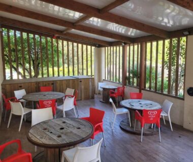 Terrasse couverte avec tables et chaises à l'Eco-Lodge Lou Pantaï
