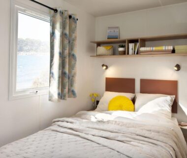 Chambre avec lit double et fenêtre sur l'eau à l'Eco-Lodge Lou Pantaï