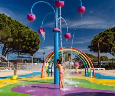 Aire de jeux aquatique avec jets et arches colorées au camping Eden 1708