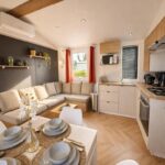 Séjour lumineux avec canapé et cuisine ouverte dans le Premium Cottage Eden Cottages
