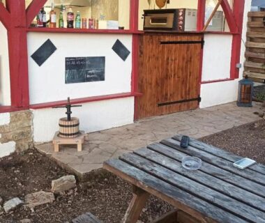 Cour extérieure avec table en bois et bar couvert à l'Emplacement tente camping car