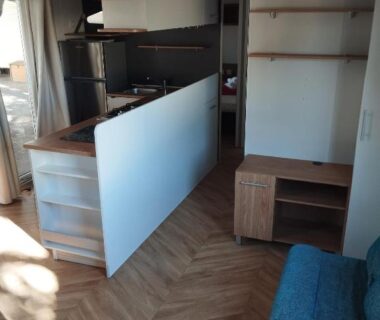 Séjour avec kitchenette et canapé dans le mobile home Entre mer et montagne