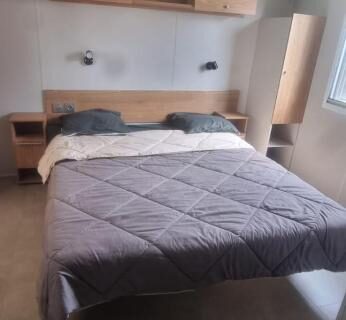 Chambre avec lit double, placard et fenêtre au camping Envie d'évasion