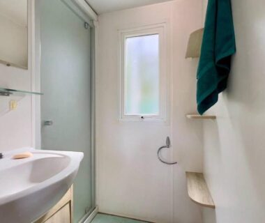 Salle d'eau avec lavabo et douche dans le mobil-home Erbarie43