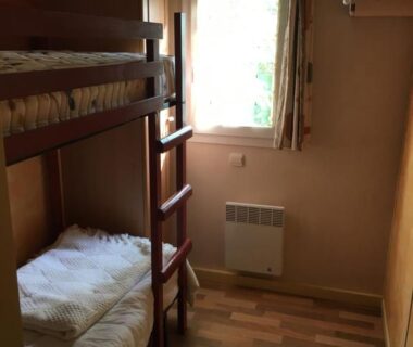 Chambre avec lits superposés et fenêtre dans le mobil-home Escale vendéenne