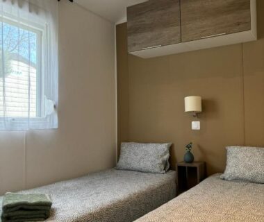 Chambre avec deux lits et serviettes dans le mobil home Escapade au Ferret