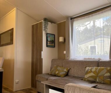 Séjour avec canapé et fenêtre dans le Mobil Home Escapade au Ferret