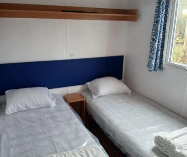 Chambre avec deux lits simples et fenêtre donnant sur l'extérieur à l'Escapade aux Peupliers