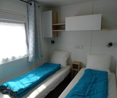 Chambre avec deux lits et fenêtre dans le mobilhome Escape MobilHome aux Dunes de Contis