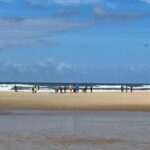 Plage avec vagues et promeneurs vue depuis Escape MobilHome aux Dunes de Contis